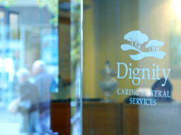 Dignity logo reflection on a glass door