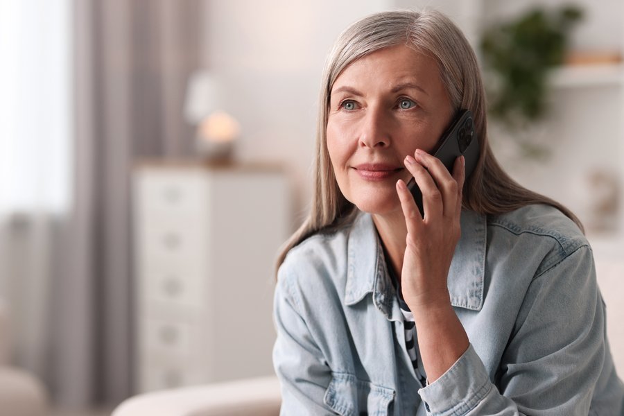A woman talking on the phone at home