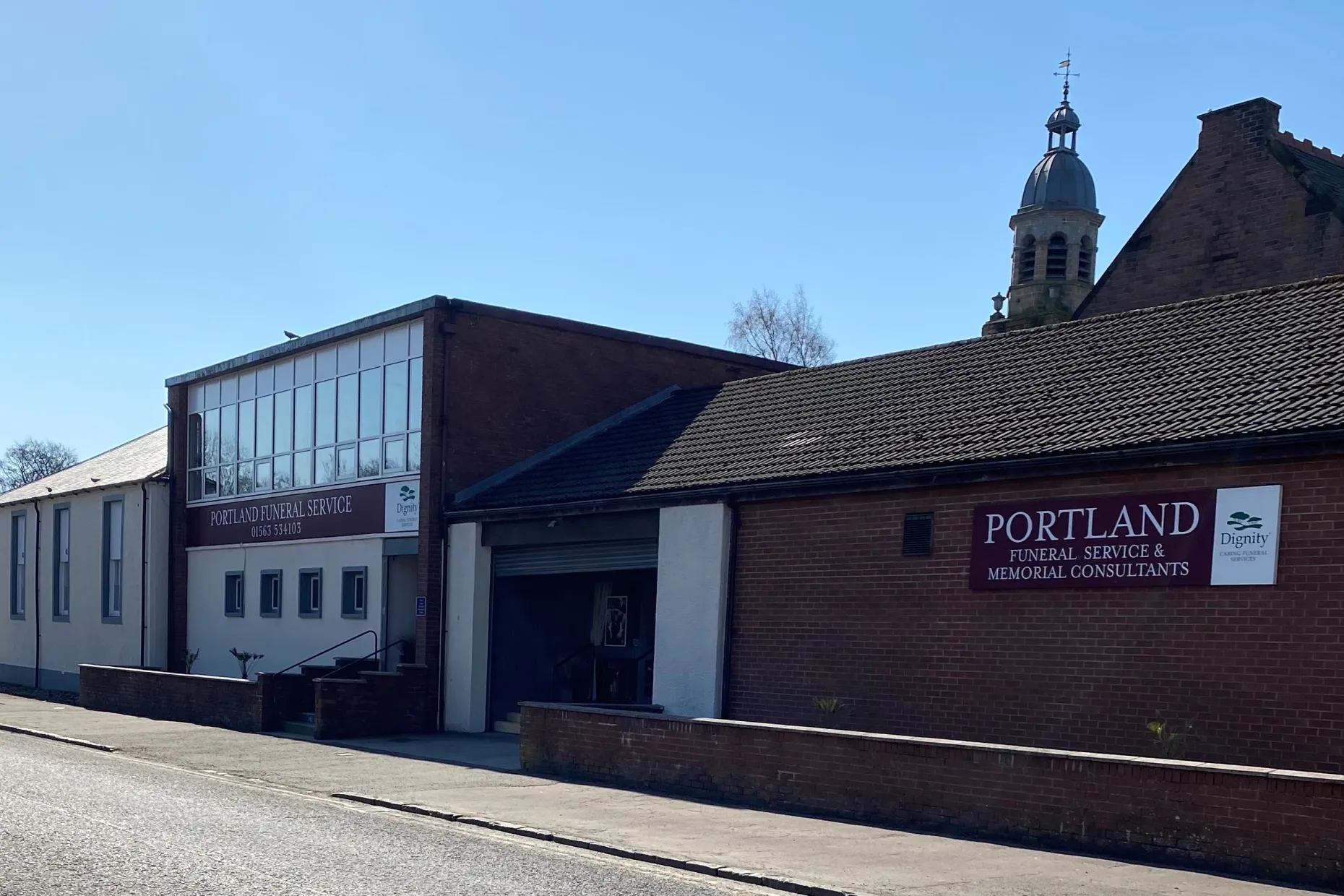 Portland Funeral Directors branch on Union Street, Kilmarnock, with a church tower behind.